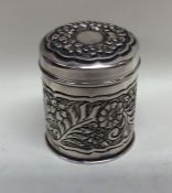 A cylindrical embossed silver tea caddy decorated