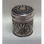 A cylindrical embossed silver tea caddy decorated