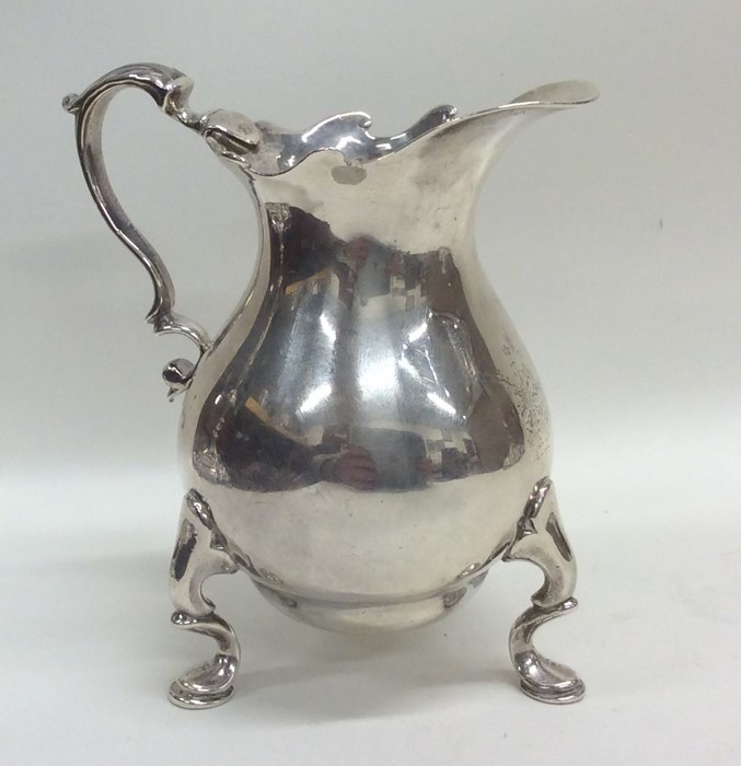 A good heavy George II silver cream jug with squat