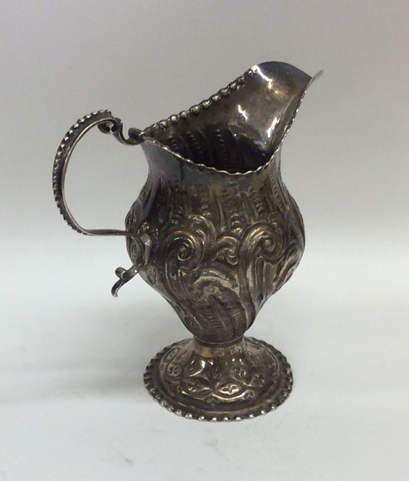 A good quality Georgian silver embossed cream jug. - Image 2 of 2