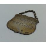 A silver Hebrew shield shaped plaque with suspensi