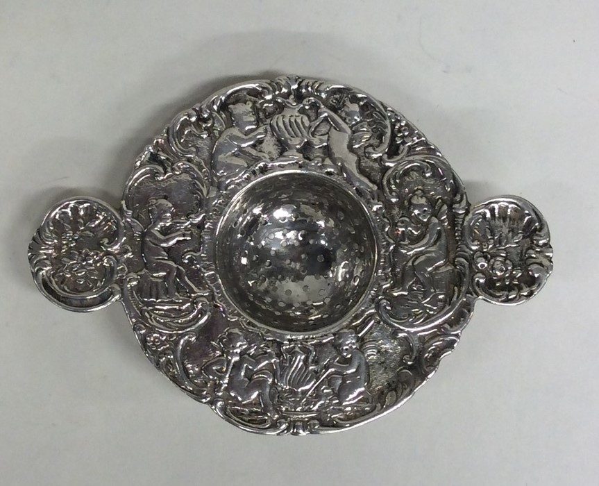 CHESTER: A heavy silver tea strainer profusely dec