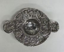 CHESTER: A heavy silver tea strainer profusely dec