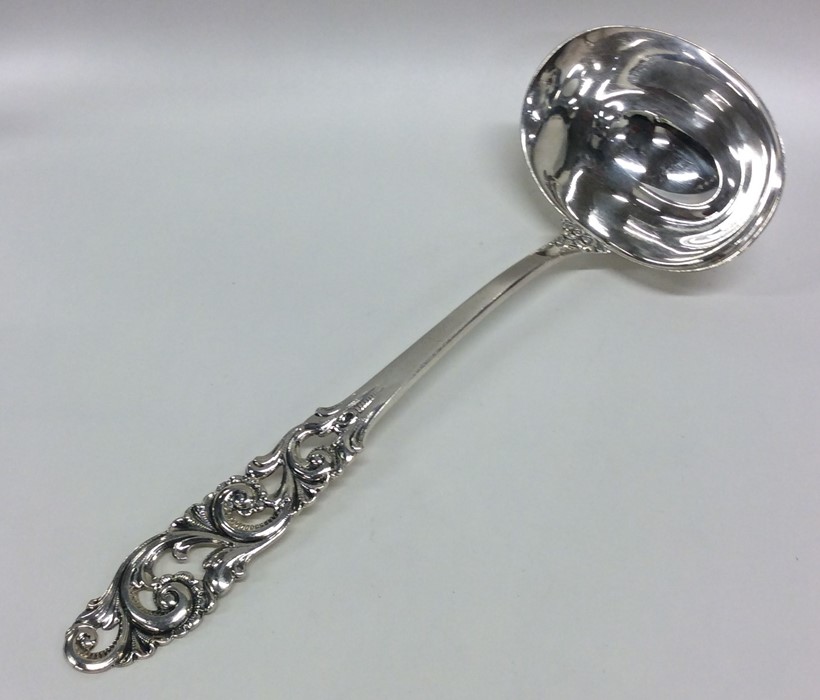 An attractive silver ladle with scroll handle. App