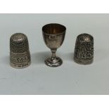 Two silver thimbles together with a miniature silv