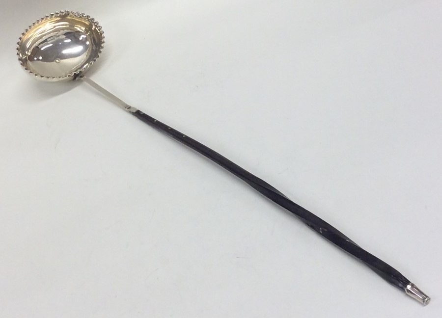 A Georgian silver toddy ladle with crimped rim. Ap