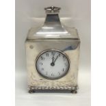 A large silver mantle clock with sweeping top to w
