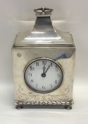 A large silver mantle clock with sweeping top to w