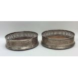 A pair of Edwardian silver wine coasters with pier