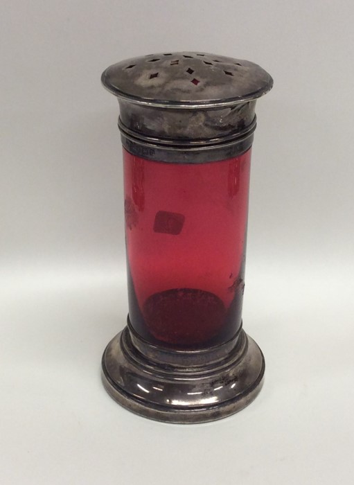 A cranberry glass sugar caster with silver mounts