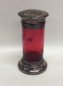 A cranberry glass sugar caster with silver mounts