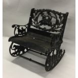 A child's cast iron mounted garden rocking chair.