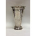 A tall tapering silver vase of textured form. Mark