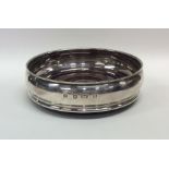 A modern silver wine coaster with mahogany base. L