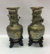 A pair of Japanese brass vases on wooden bases. Es