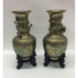 A pair of Japanese brass vases on wooden bases. Es