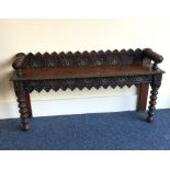 An oak carved hall bench with turned legs. Est. £4