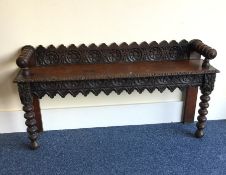An oak carved hall bench with turned legs. Est. £4