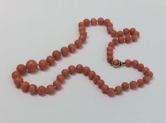 A graduated string of coral beads with concealed c