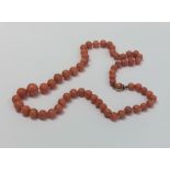 A graduated string of coral beads with concealed c