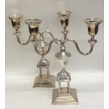 A pair of silver plated candlesticks on stepped ba