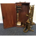 A cased brass microscope complete with lenses. By