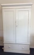 A painted pine two door wardrobe with drawer to ba