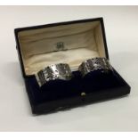 A pair of Continental silver napkin rings in fitte