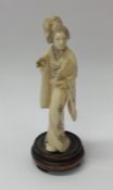 A carved ivory figure of a lady on wooden base. Es