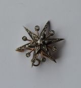 A diamond brooch in the form of a star with loop t