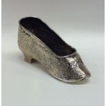 A chased silver novelty in the form of a shoe attr