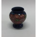 A small Moorcroft vase with floral decoration. Est