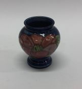 A small Moorcroft vase with floral decoration. Est