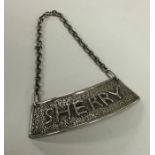 A large silver wine label for 'Sherry' of textured