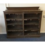 An oak bookcase with shaped top. Est. £40 - £60.
