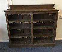 An oak bookcase with shaped top. Est. £40 - £60.