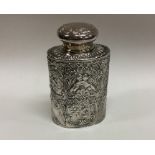 An embossed oval silver top tea caddy decorated wi