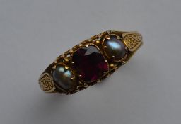 An Antique garnet and pearl ring attractively engr