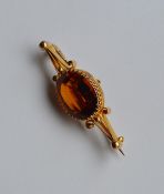 An Antique single stone topaz brooch in gold claw