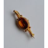 An Antique single stone topaz brooch in gold claw