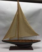 A large wooden model of a sailing yacht with teak