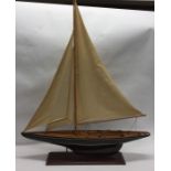 A large wooden model of a sailing yacht with teak