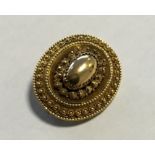 An oval gold target brooch with ball decoration. A