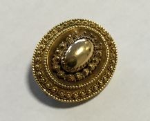 An oval gold target brooch with ball decoration. A