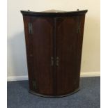 An Antique oak corner cupboard with brass hinges.