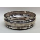 A modern silver wine coaster with mahogany base. L