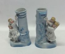 A pair of decorative spill vases depicting childre