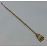 An Antique carved ivory back scratcher in the form