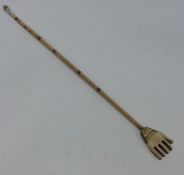 An Antique carved ivory back scratcher in the form