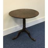 A Georgian mahogany tilt top table on turned suppo